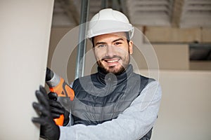 portrait smiling male builder using cordless drill