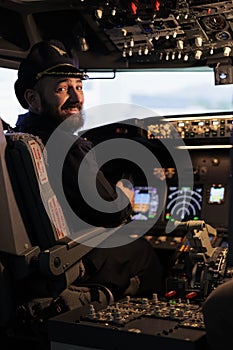 Portrait of smiling male captain flying airplane with panel command