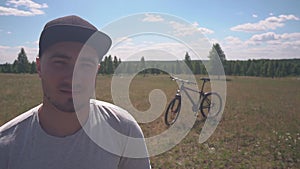 Portrait of Smiling Male Cyclist Enjoying Life. Behind Him is a Bicycle. Healthy Man with Cycling Along Enjoying the