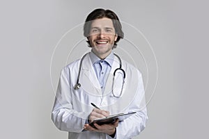 Portrait of smiling male doctor holding clipboard and taking patients history