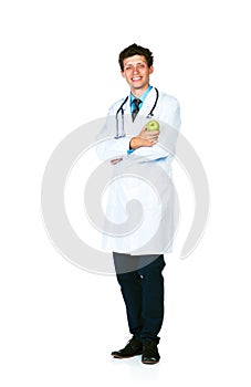 Portrait of a smiling male doctor holding green apple on white