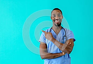 Portrait of a smiling male doctor or nurse pointing with finger  to side