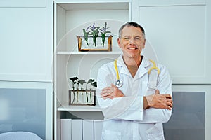 portrait of smiling male doctor with stethoscope looking at camera in hospital