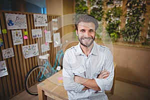 Portrait of smiling male executive standing with arms crossed