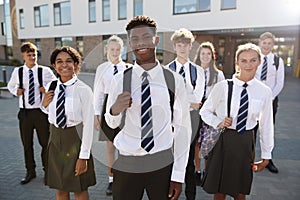 Portrait Of Smiling Male And Female High School Students Wearing Uniform Outside College Building photo