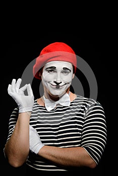 Portrait of smiling male mime on black