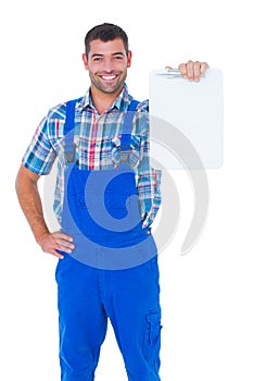 Portrait of smiling male repairman showing clipboard