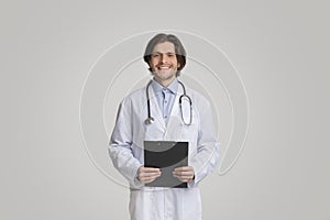Portrait Of Smiling Male Therapist Posing With Clipboard In Hands