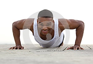Portrait of a smiling man doing push ups
