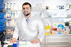 Portrait of smiling man druggist standing at counter
