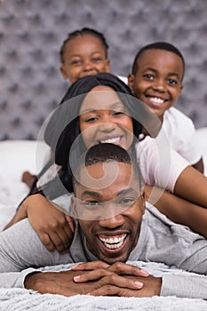 Portrait of smiling man with family lying on bed