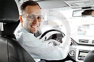 Portrait of smiling man in his car. Business taxi driver. Looking camera. saloon view