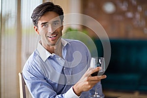 Portrait of smiling man holding glass of red wine