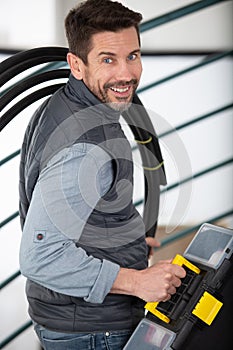 portrait smiling man holding tool box