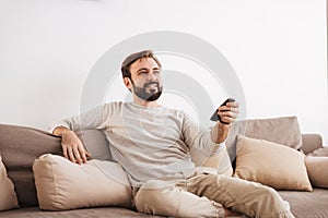 Portrait of a smiling man holding remote control