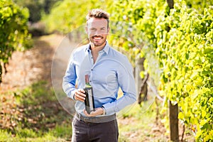 Portrait of smiling man holding wine bottle