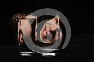 portrait of a smiling man looking through two glasses