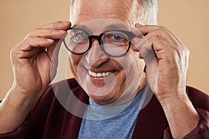 Portrait of smiling man putting on his glasses