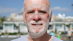 Portrait of smiling man standing outdoors looking at camera. Pensioner traveling in Moscow, Russia