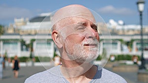 Portrait of smiling man standing outdoors looking at camera. Pensioner traveling in Moscow, Russia