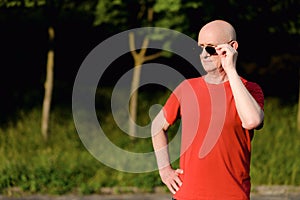 Portrait of smiling man wearing sunglasses and looking away in the city streets.