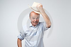 Portrait of a smiling mature european man putting hat off