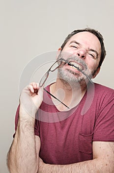 Portrait of a smiling mature man with beard wearing red t-shirt and glasses