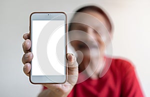 Portrait of smiling mature man holding smartphone with white blank screen in hand