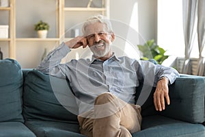 Portrait smiling mature man sitting on couch at home