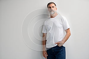 Portrait of smiling mature man standing on white background.