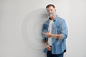 Portrait of smiling mature man standing on white background.