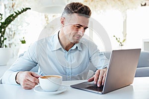 Portrait of a smiling mature man using laptop