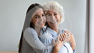 Portrait of smiling mature mom and adult daughter hugging