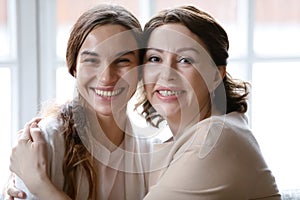 Portrait of smiling mature mother and adult daughter