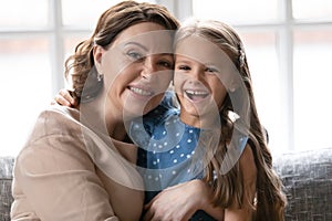 Portrait of smiling mature woman posing with little granddaughter