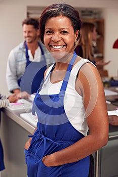 Portrait Of Smiling Mature Woman Wearing Apron Taking Part In Cookery Class In Kitchen