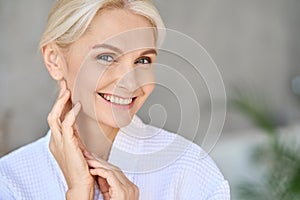 Portrait of smiling mid age woman looking at camera. Skin care concept.