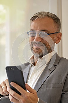 Portrait of Smiling Middle Aged Businessman With Cell Phone