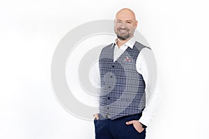 Portrait of smiling middle-aged businessman wearing grey checkered vest, white shirt, blue jeans, standing, posing.
