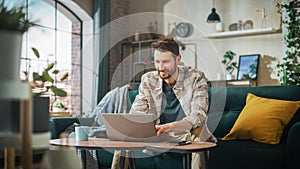 Portrait of Smiling Middle Aged Man Working from Home on a Laptop Computer in Sunny Cozy Apartment