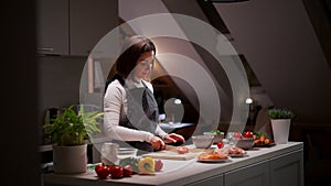 Portrait of smiling millennial woman cooking healthy vegetarian food standing in kitchen