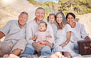 Portrait of a smiling mixed race family with little girls sitting together at the beach. Adorable little kids bonding