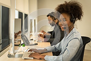 Portrait of smiling mixed race female call center or help desk or telephone support agent working