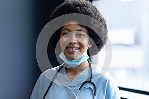 Portrait of smiling mixed race female doctor wearing face mask