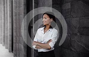 Portrait of a Smiling Mixed Races Business Woman, Crossed Arm and Looking away in City
