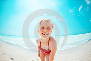 Portrait of smiling modern child in red beachwear on seacoast