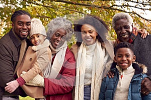 Portrait Of Smiling Multi-Generation Family Having Fun Walking Through Autumn Countryside Together