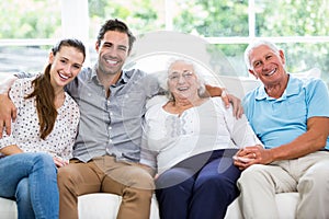 Portrait of smiling multi-generation family sitting on sofa