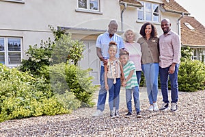 Portrait Of Smiling Multi-Generation Family Standing Outside Home Together