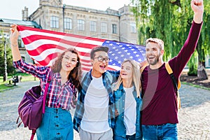 portrait of smiling multicultural students with american flag